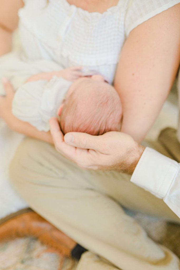 Dad holding the back of baby head during lifestyle session