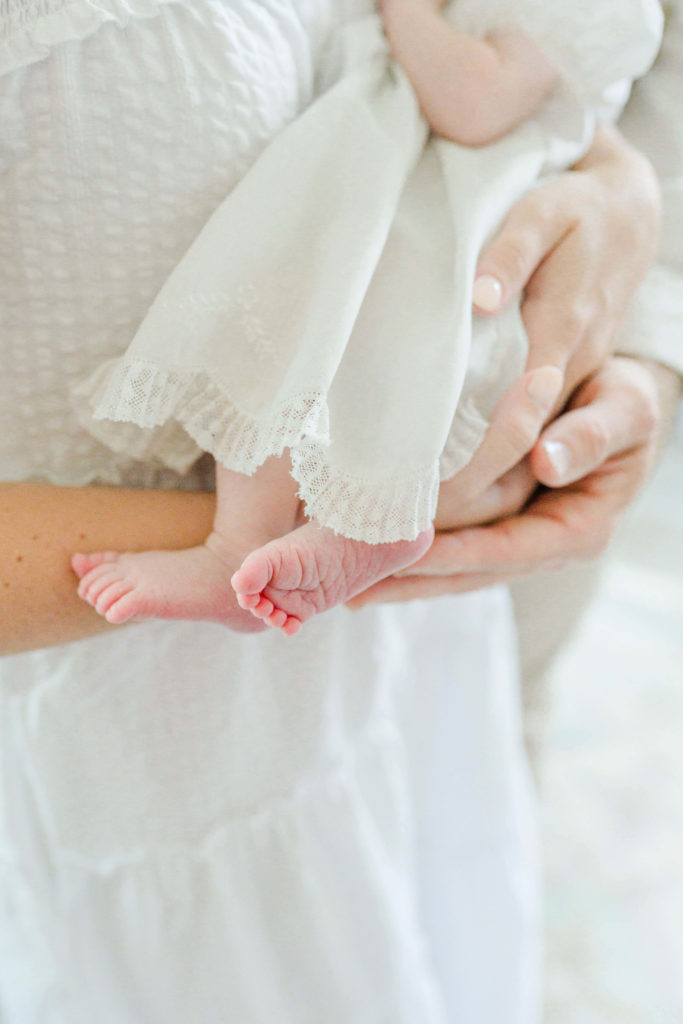 Detail of baby feet and dress edge during lifestyle session