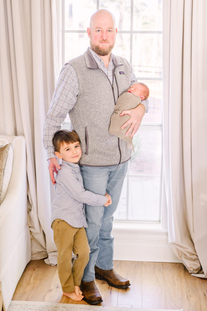 Picture of dad, big brother and baby. 