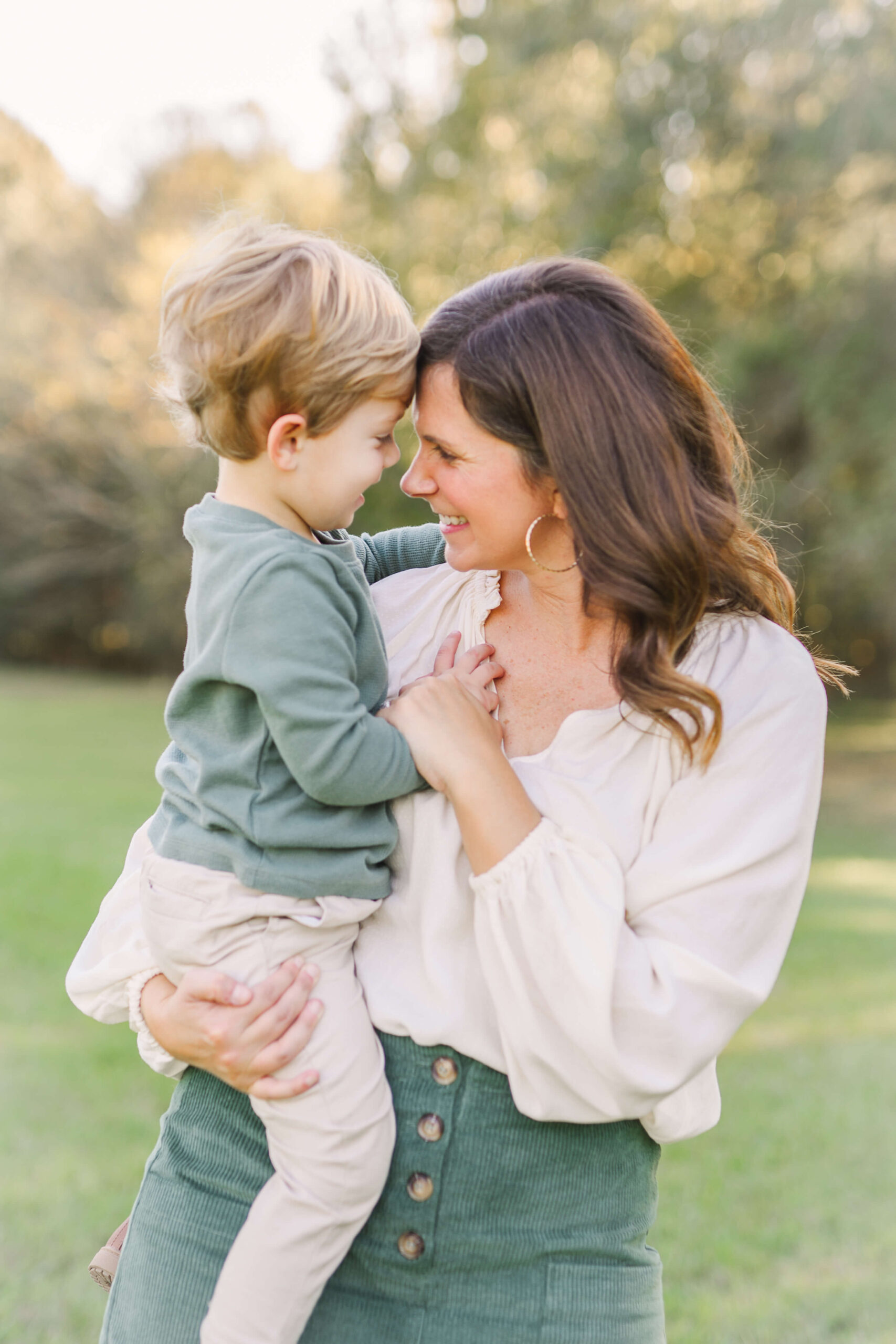 Mom holding her toddler son, holding hands and looking at one another, Parents interacting naturally during mini session guide