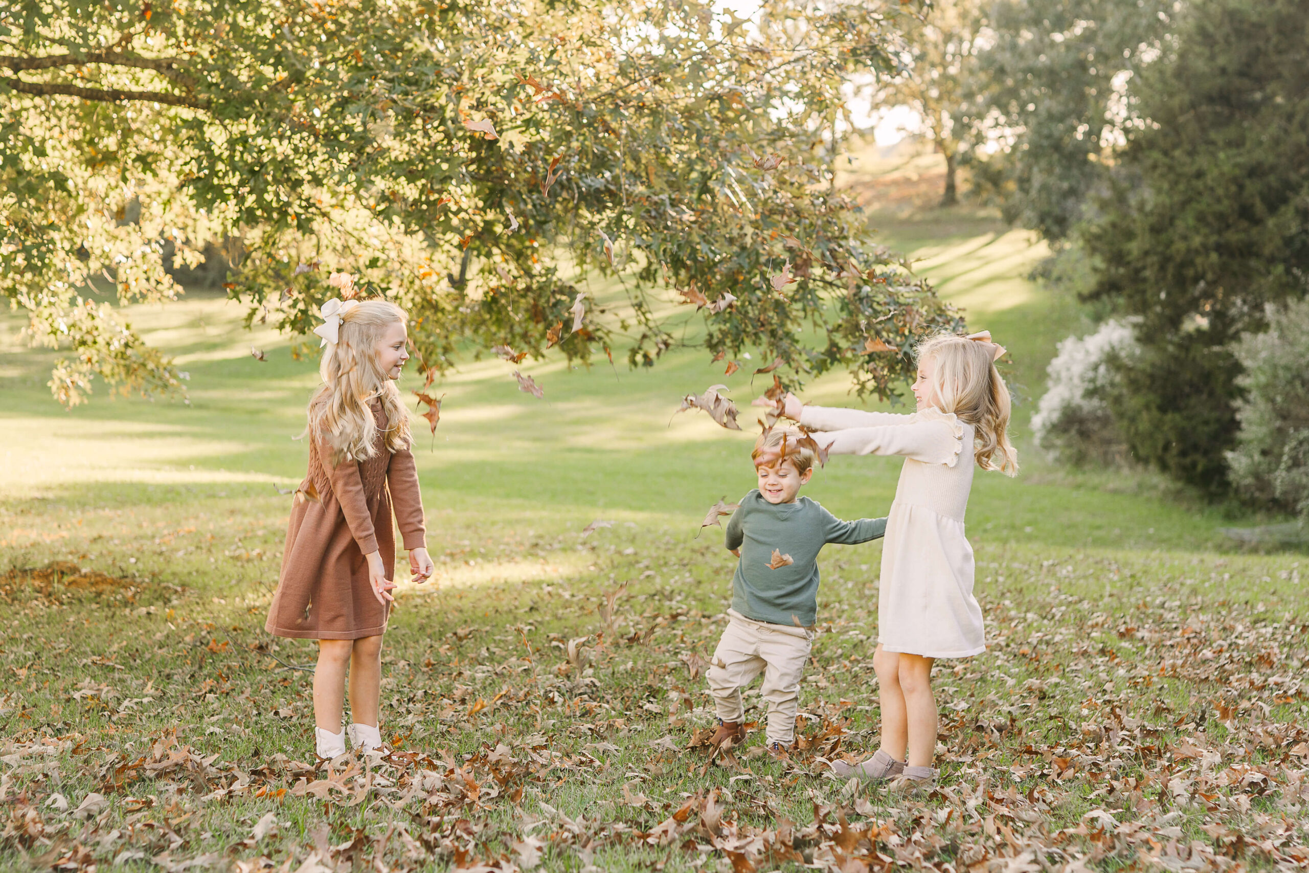 3 siblings playing throw the leaves during a fall family session, Candid family moments during mini session guide