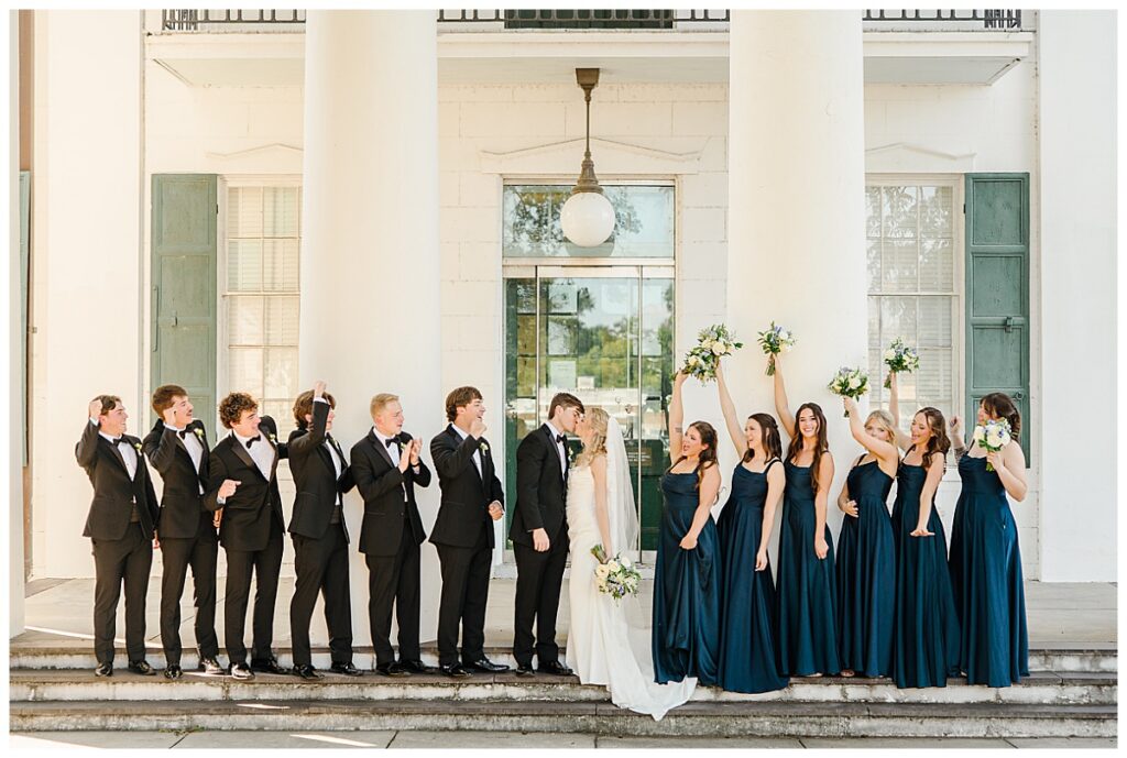 Anna and John Parker with their bridesmaids and groomsmen outside The Raymond Venue in Raymond, Mississippi.